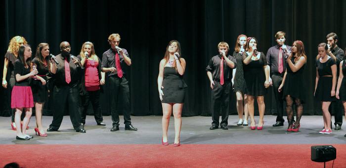 MCC co-ed vocal ensemble performing on stage.